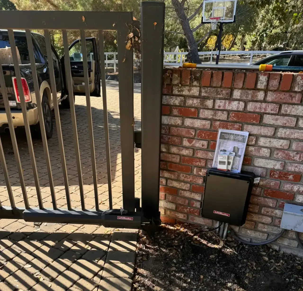 LiftMaster LA500 swing gate operator and control box installed on a brick pillar