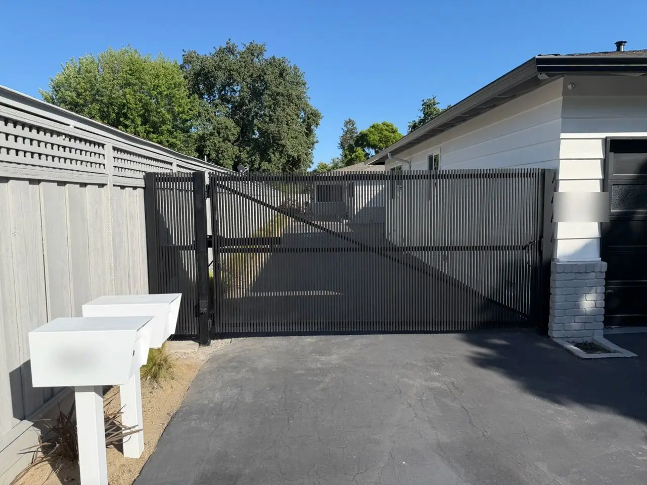 Black vertical-slat automatic double swing driveway gate